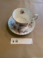 Tea cup on saucer showing floral design and gold trim