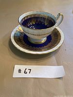 Teacup on saucer showing cobalt blue band and gold gilt pattern