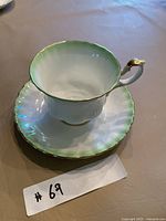 Teacup on saucer showing color gradient and gold trim