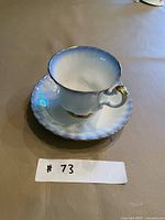 Teacup on saucer front view showing color and gold trim