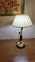 Full view of brass and black desk lamp on wood surface