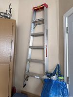 Full view of aluminum step ladder leaning against wall