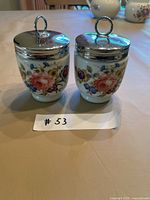 Front view of both Royal Worcester egg coddlers showing floral pattern and lids