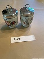 Front view of both egg coddlers with motifs visible