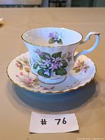 Teacup on saucer showing pattern and gold trim