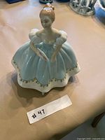 Front angled view of figurine showing dress detail and fan