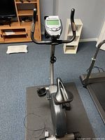 Full view of Schwinn upright bike from front showing seat, console, pedals and mat