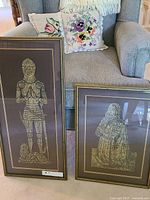 Both framed brass rubbing prints shown together for scale and comparison