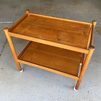 three-quarter view of teak cart showing both shelves and casters