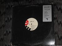 Front of black sleeve with vinyl partially visible and hype sticker