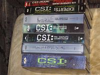 Spine view of stacked DVD box sets showing all seasons and bonus disc