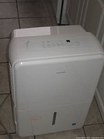 Front view of Insignia dehumidifier showing water-level window and overall condition