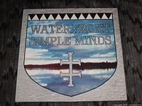 Front of 12" single sleeve showing Water Front Simple Minds shield artwork
