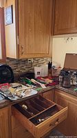 Overview of countertop with utensils, coffee maker, drawer of cutlery