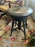 Full view of piano stool showing seat, legs, and feet