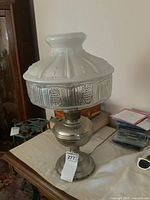 Full view of converted oil lamp showing metal base, glass shade and power cord