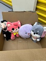 All four plush toys inside cardboard box