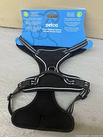 Front view of harness with retail card showing Petco branding, size L, reflective accents