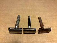 Three razors standing upright showing overall form and finishes