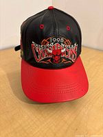 Front view of leather hat showing main embroidered logo and red brim