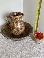 Pitcher inside matching bowl, measuring tape indicates scale