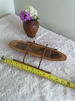 Top view of wood sleigh beside tape measure showing dimensions
