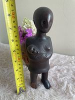 Full view of sculpture beside tape measure showing height