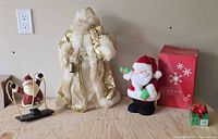 Gold/white Santa tree topper, plush remote Santa, swing Santa, green receiver box, Avon box in background