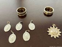 Group shot showing two rings, four oval pendants, sun pendant