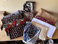 Multiple folded fabric pieces showing variety of prints and solids on tabletop