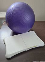 Nintendo Wii Balance Board and purple exercise ball on table