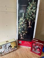 All three boxed items: pre-lit trees, glass nativity, glass ornaments