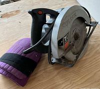 Side view of Skilsaw circular saw with purple knee pad visible