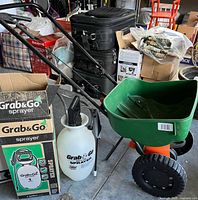 Sprayer in box next to green Scotts spreader