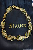Bracelet on Stauer pouch showing brand logo, clasp, stones and crystal links