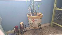 Ceramic planter on metal stand with vases at base