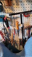 Upper left pegboard area with work light, chisels, screwdrivers, C-clamp