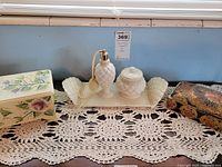 Overall lot showing two jewelry boxes, milk glass vanity set and doily
