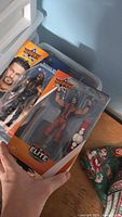 Two sealed WWE Elite Collection SummerSlam action figures in front of plastic tote