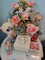 Overview of lot on table: floral arrangement, shell box, gift box with beads, dolls, Ty lamb plush, planner packet