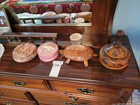 All four trinket boxes lined on dresser