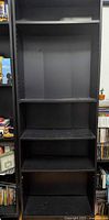 Front view of tall black IKEA Billy bookcase showing five shelf levels
