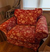 Front angled view of red floral IKEA Ektorp armchair