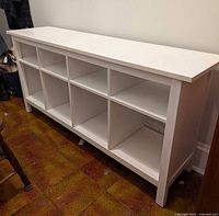 Front angled view of white IKEA Hemnes TV table showing cubby layout