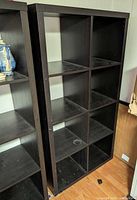 Front view of dark espresso IKEA Kallax 8-cube shelving unit showing all compartments and visible wear