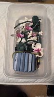 Overview of assembled LEGO Orchid model in plastic storage bin