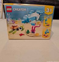 Front of LEGO Creator 3-in-1 Dolphin and Turtle Set 31128 box showing piece count, age range and visible shelf wear