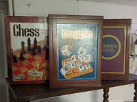 Front view of three wooden bookshelf-style game cases: Chess, Boggle, Scrabble
