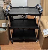 Cart fully assembled showing three shelves, handles, caster wheels