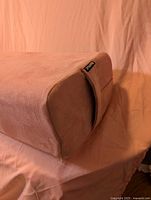 Perspective view showing end, side handle, woven tag of dusty pink rectangular yoga bolster